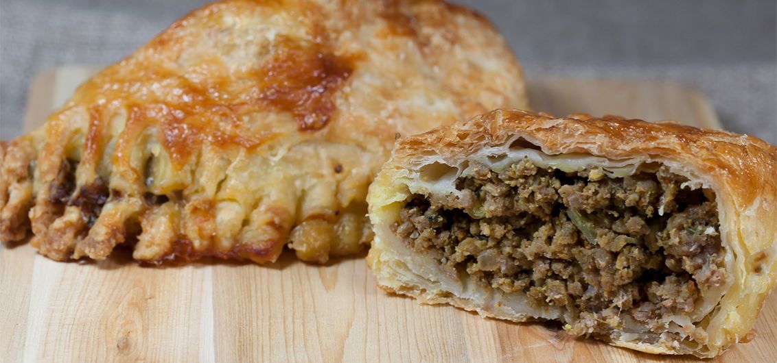 Piroggen mit Hackfleisch gefüllt auf Holzbrett