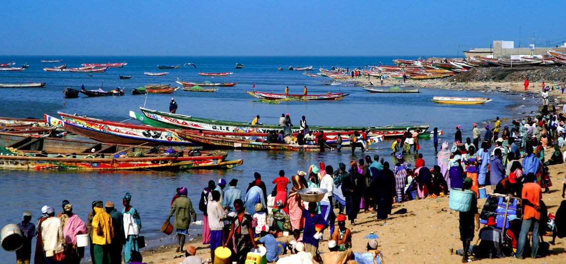 Fischerboote und Markttreiben am Strand von Mbour