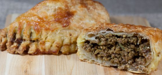 Piroggen mit Hackfleisch gefüllt auf Holzbrett